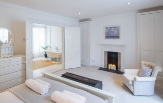 boutique style bedroom dressed with crisp white Egyptian bed linen & fluffy white towels | Blue Monkey Cornwall