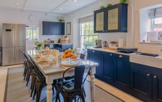 Kitchen laid out to be family friendly with high chairs and a large table to sit down and have meals with the family